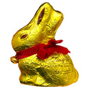 Gold foil-wrapped chocolate bunny with a red bow tie on a white background
